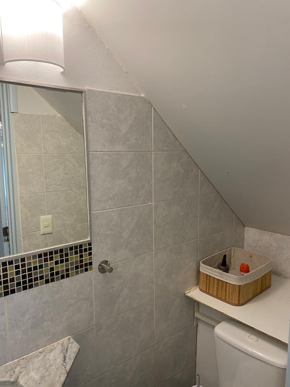 Baño con ducha con mampara, bacha celeste sobre mesada de madera y espejo
