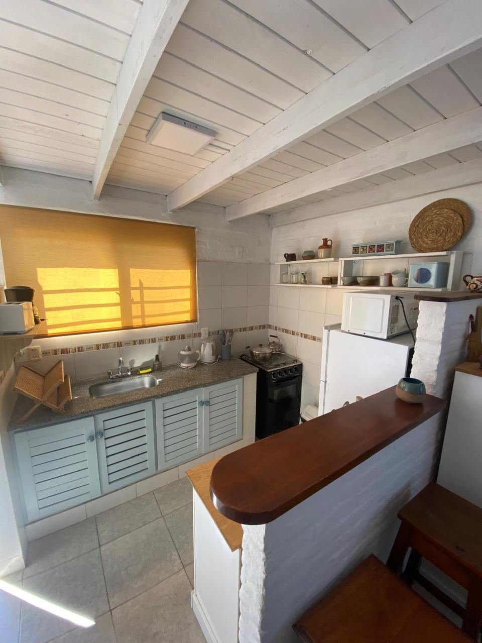 Cocina equipada con mesada, barra de madera y alacenas